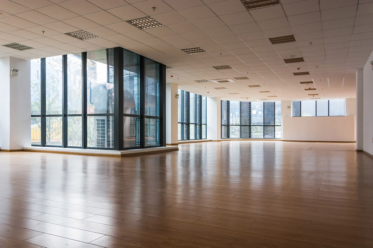 The interior of a modern commercial building with many windows during the day.